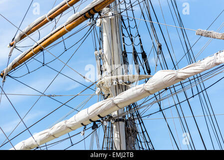Masten, Takelage und Segel eines Segelbootes hoch gerollt Stockfoto