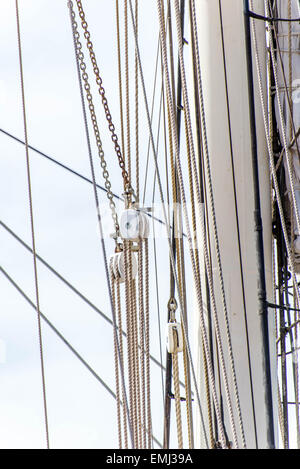 Masten, Takelage und Segel eines Segelbootes hoch gerollt Stockfoto
