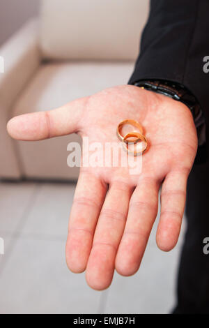 Trauringe auf der Handfläche des Bräutigams, Heiratsantrag Stockfoto