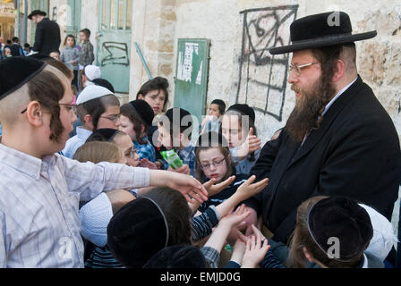 Ein Ultra-orthodoxen Juden Mann Essen austeilen, um arme Kinder in Jerusalem Israel Stockfoto