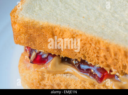 Makro Nahaufnahme von Ecke eines Peanut Butter Jelly Sandwich mit Weißbrot.  Marmelade und Erdnussbutter sind heraus tropft. Stockfoto