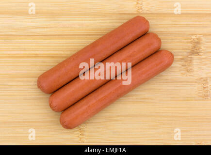 Draufsicht von drei alle Rindfleisch Hotdogs auf ein Holz Schneidebrett. Stockfoto