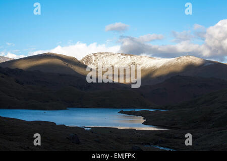 Sonnenlicht fangen die Schnee bedeckten Gipfel des Fairfield von in der Nähe von Easedale Tarn über Grasmere Cumbria England Stockfoto