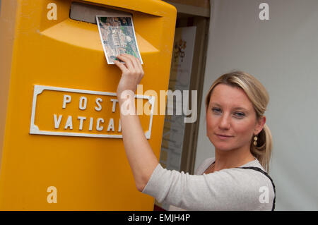 Hübsche Mädchen, die Entsendung einer Karte in einem gelben Vatikan Briefkasten, Vatikan Stockfoto