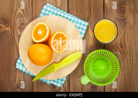 Orangen und ein Glas Saft. Blick von oben über Holztisch Hintergrund Stockfoto