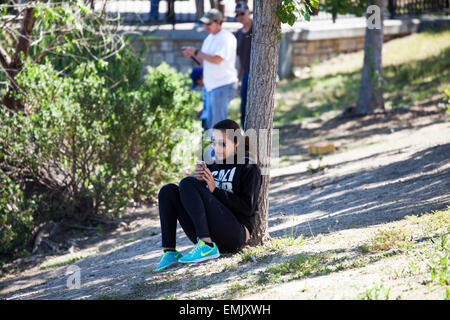 Frau SMS in einem Park, Novato, Marin County, Kalifornien, USA Stockfoto