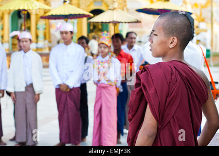 YANGON, MYANMAR - 29. Januar: Junge buddhistischer Mönch die Novication-Zeremonie an der Shwedagon-Tempel beobachtet 29. Januar 2010. Ein kleiner Junge wird in ein Novize gemacht. Stockfoto