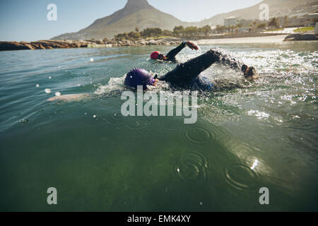 Triathlon-Schwimmer das Wasser am laufenden Band. Sportler üben für triathletic Rennen in See. Stockfoto