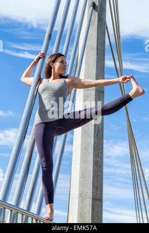Ausgestreckte Hand bis zu den Zehen Yoga-Pose auf einer Brücke, San Diego, Kalifornien durchgeführt Stockfoto