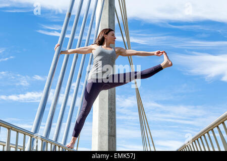Ausgestreckte Hand zur Großzehe Yoga-Pose auf einer Brücke, San Diego, Kalifornien durchgeführt Stockfoto