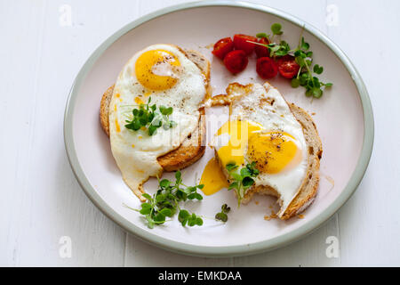 Frühstück, Eiern auf Toast mit Kirschtomaten und Kresse Stockfoto