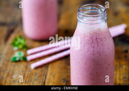 Himbeer Smoothie in Milchflaschen Stockfoto