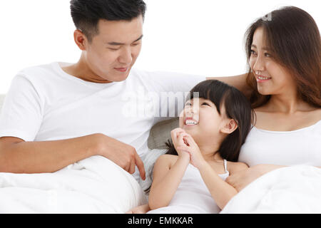 Eine dreiköpfige Familie saß auf dem Bett im Schlafzimmer Stockfoto