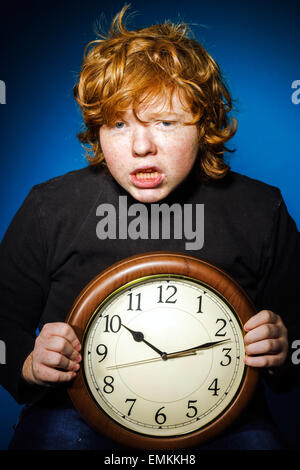 Expressive Rothaarige Teenager zeigt Zeit auf große Uhr, Business und Konzept Stockfoto