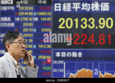 Tokio, Japan. 22. April 2015. Ein Mann geht vorbei an einer Elektronikplatine zeigt der Aktienindex in Tokio, Japan, am 22. April 2015. Der Nikkei-Index für 225-Thema sprang 224,81 Punkte oder 1,13 Prozent von Dienstag bei 20,133.90, dem höchsten Abschluss seit April 2000. © Stringer/Xinhua/Alamy Live-Nachrichten Stockfoto