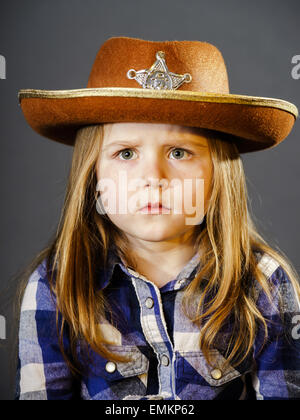 Niedliche kleine Mädchen gekleidet in Hemd und Sheriff Cowboyhut, isolierte Studioportrait Stockfoto