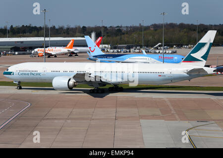 Cathay Pacific Boeing 777-300 taxis, die aktive Start-und Landebahn am Flughafen Manchester. Stockfoto