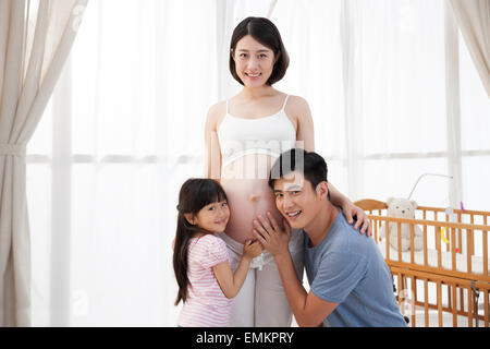 Der junge Vater und Kinder hören den Mutterleib Stockfoto