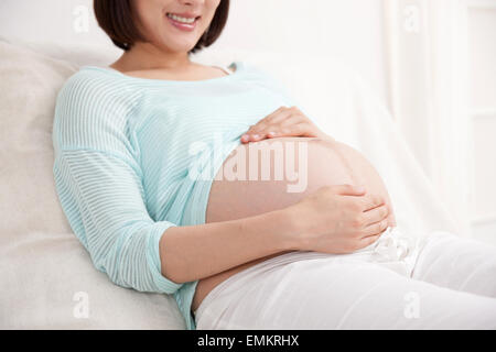 Die schwangere Frau im Bett liegend Stockfoto