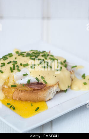 Eggs Benedict geröstet, englische Muffins Schinken pochierten Eiern und köstliche buttrige Sauce Hollandaise Stockfoto