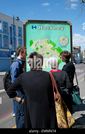 Hackney, London. Stoke Newington High Street. Personen suchen in einer öffentlichen Karte. Stockfoto