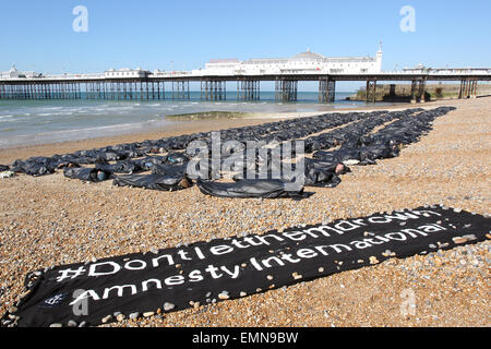 Brighton, UK. 22. April 2015. Aktivisten nehmen Teil an einer Demonstration organisiert von Amnesty Großbritanniens Antwort auf die rasant steigenden Flüchtlingskrise im Mittelmeer, an der Pier in Brighton zu markieren. 200 Schwarz Leichensäcke wurden aufgereiht am Strand und Anhänger wurden gezippt. Bildnachweis: Randi Sokoloff/Alamy Live-Nachrichten Stockfoto