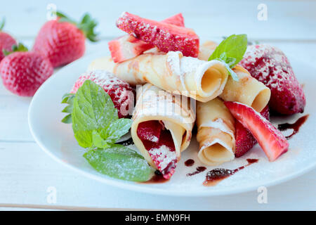 Pfannkuchen mit Erdbeeren Früchte und Schokolade Glasieren und weißen Puderzucker Stockfoto