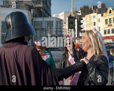 Auf eine Henne zu tun in Brighton trifft eine Braut zu sein ein Straßenkünstler, als Darth Vader verkleidet Stockfoto