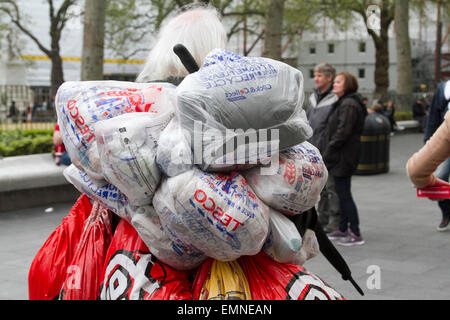 London, UK. 22. April 2015. Ein Landstreicher trägt Tesco-Einkaufstüten in Leicester Square.  Tesco-Supermarkt hatte angekündigt, einen £6 .3billion gesetzlichen Verlust das Schlimmste in der Geschichte des Unternehmens Credit: Amer Ghazzal/Alamy Live-Nachrichten Stockfoto