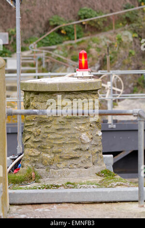 Rote Warnleuchte auf Hafenmauer zu warnen, Boot Skipper des Bootes betreten oder verlassen Polperro, Cornwall, England Stockfoto