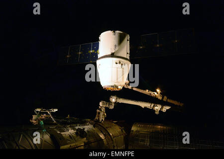 Canadarm-2 zieht die SpaceX Dragon-Fracht-Sonde in den Hafen auf der internationalen Raumstation ISS 17. April 2015 in der Erdumlaufbahn. Die Dragon-Kapsel trägt Lieferungen und Fracht für Besatzungsmitglieder an Bord der ISS. Stockfoto