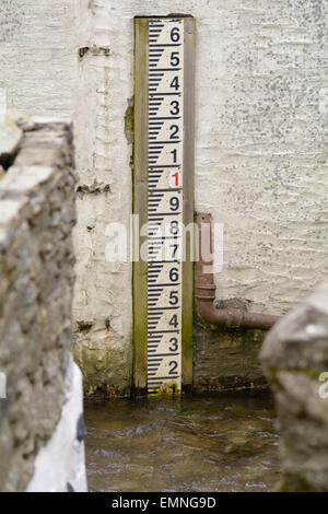 Wasser-Tiefe-Marker im Stream in Polperro, Cornwall, England Stockfoto