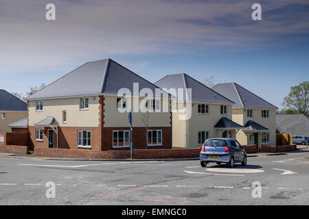 NEUBAU HÄUSER AT STRAßENKREUZUNG IN TUTSHILL GLOUCESTERSHIRE UK MIT AUTO CROSSING MINIKREISVERKEHR UK Stockfoto