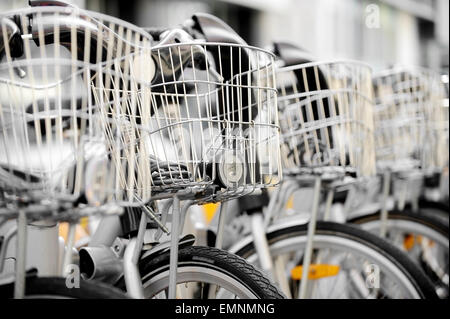 City-Fahrräder mit Korb vorn sind in eine Verleihstation gesehen. Stockfoto