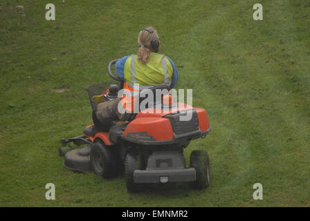 Man Schneiden von Gras mit Aufsitzendem lawn Mover. Gärtner der Aufrechterhaltung offener Raum. Wartung der Parklandschaft. Stockfoto