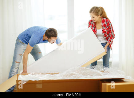 lächelnde paar Eröffnung großer Karton mit sofa Stockfoto