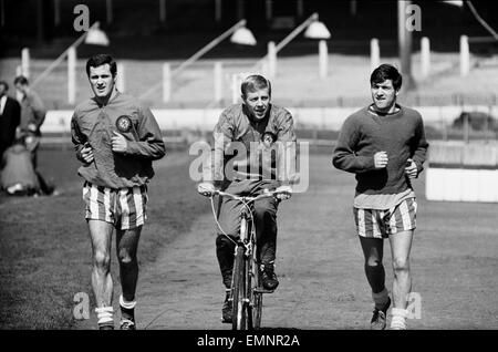 Chelsea-Spieler im Training vor ihrer FA-Cup-Halbfinale gegen Sheffield Mittwoch im Villa Park, 21. April 1966. Die Strecke das Läppen ist England International Ken Shellito auf seinem Fahrrad mit l-R George Graham & Terry Venables. Stockfoto