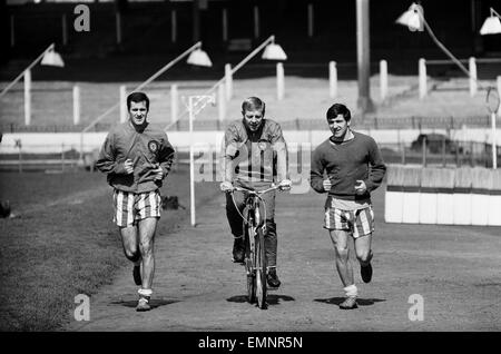 Chelsea-Spieler im Training vor ihrer FA-Cup-Halbfinale gegen Sheffield Mittwoch im Villa Park, 21. April 1966. Die Strecke das Läppen ist England International Ken Shellito auf seinem Fahrrad mit l-R George Graham & Terry Venables. Stockfoto