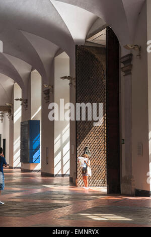 Frau reisen, Blick auf eine solo Frau reisender Lesen einer Karte innerhalb des gewölbten Atrium des Palazzo Ducale, Genua, Italien. Stockfoto