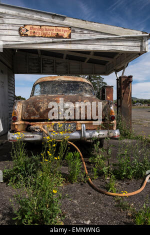 Alte verlassene Tankstelle mit einem Plymouth Belvedere 1950er Jahren Auto und zwei Zapfsäulen verrotten auf dem Vorplatz. Ormondville, Stockfoto