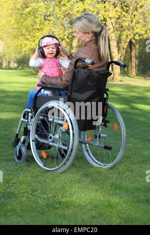 Eine Mutter im Rollstuhl mit Baby auf dem Schoß Stockfoto