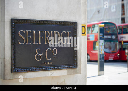 LONDON, UK - APRIL 22: Ladenschild an der Ecke des berühmten Kaufhauses Selfridge & Co., in der Oxford Street, mit rotem Doppel-dec Stockfoto