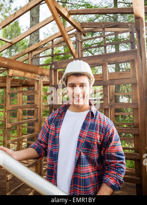 Glücklich Construction Worker Holding Blaupause am Standort Stockfoto