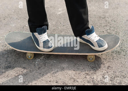 Skateboarder Füße in Turnschuhen auf einem Skateboard. Stockfoto