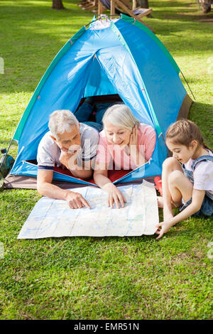 Großeltern mit Enkelin Studium Karte auf Campingplatz Stockfoto