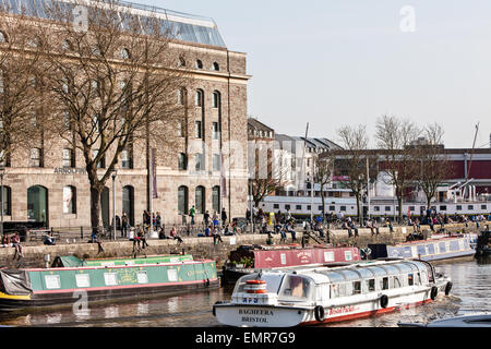 Bristol, mit schmalen Boote und Peros Bridge in Bristol City Centre, England, Europa am Hafen sitzen. Ende März. Sonnig Stockfoto