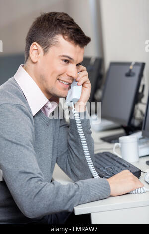 Customer Service Representative mit Festnetz-Telefon am Schreibtisch Stockfoto