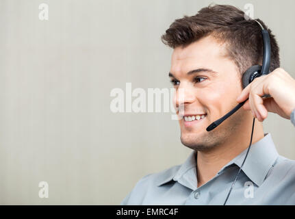 Call-Center Mitarbeiter mit Kopfhörer während wegschauen Stockfoto