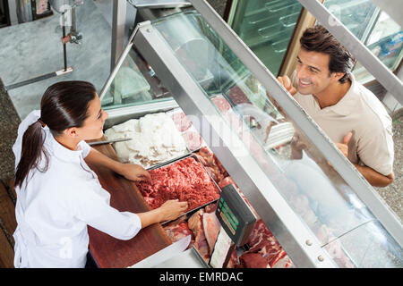 Metzger Hackfleisch an männlichen Kunden zu verkaufen Stockfoto