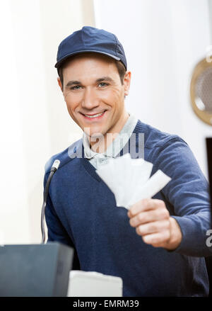 Lächelnde Arbeiter mit Tickets an der Abendkasse Stockfoto